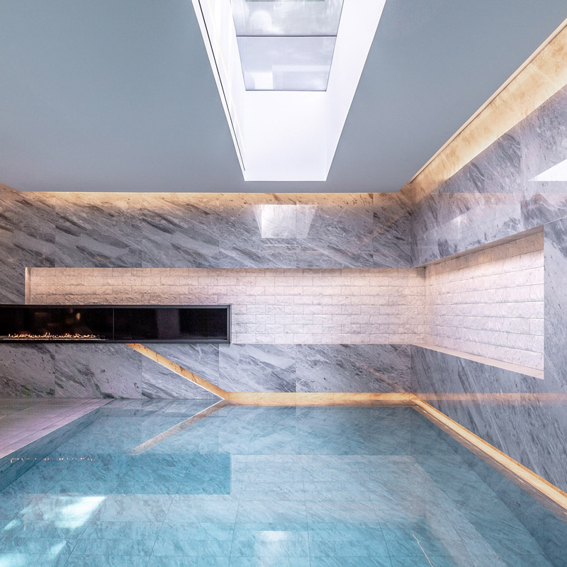 Wnętrze basenu w IO House London z oświetleniem LED i świetlikiem odbijającym się w wodzie - dpa lighting i Taran Wilkhu