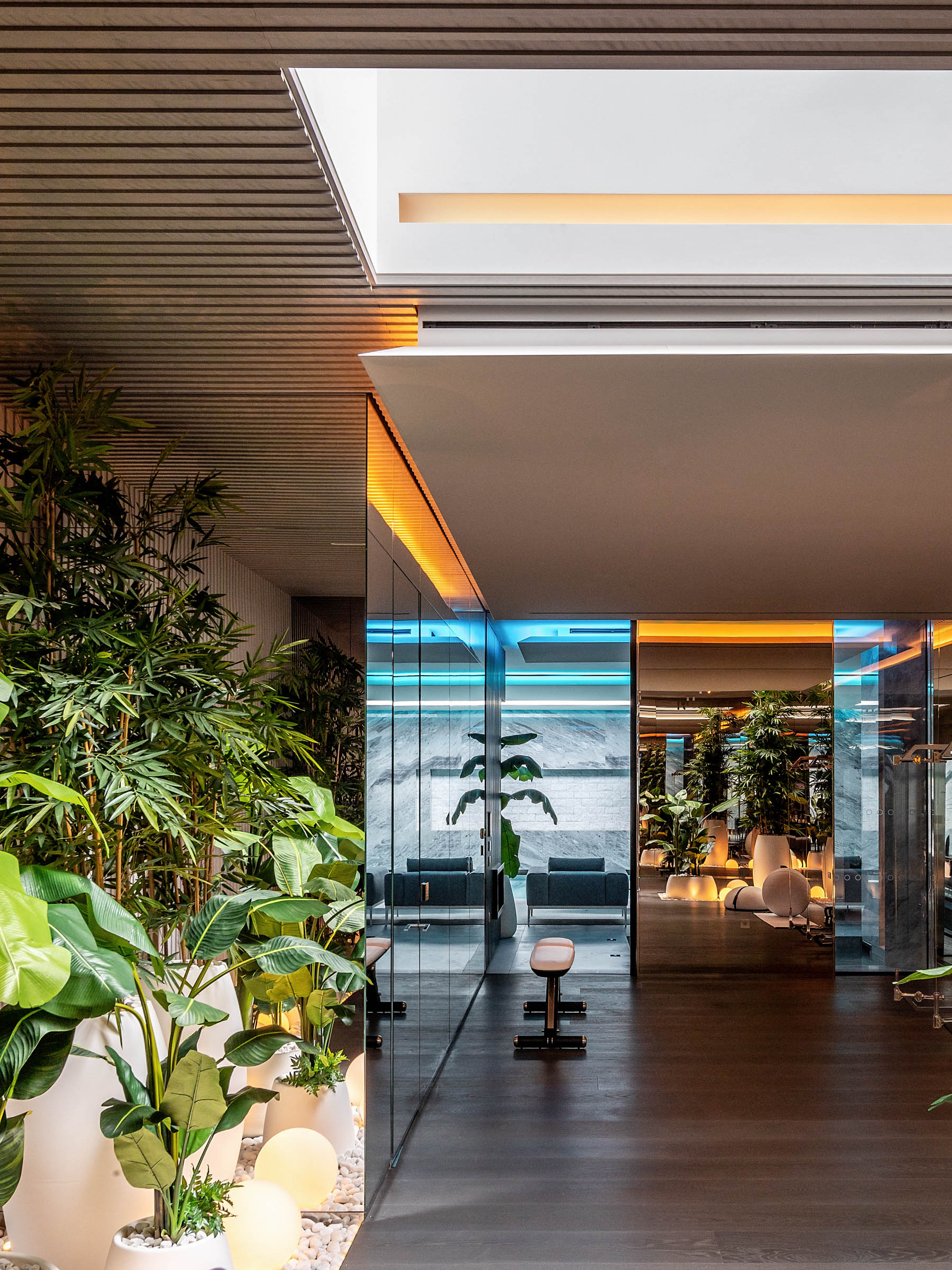 IO House London interior with greenery and plants showing diverse LED lighting with skylight and wooden interior panels - dpa lighting and Taran Wilkhu