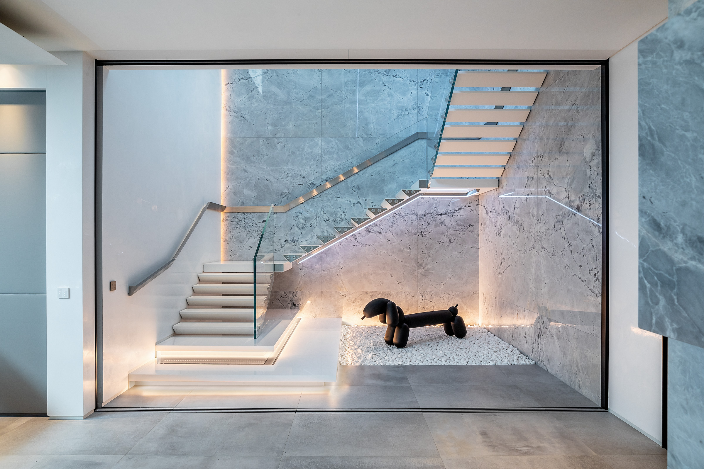 IO House London interior staircase with modern dog sculpture - dpa lighting and Taran Wilkhu