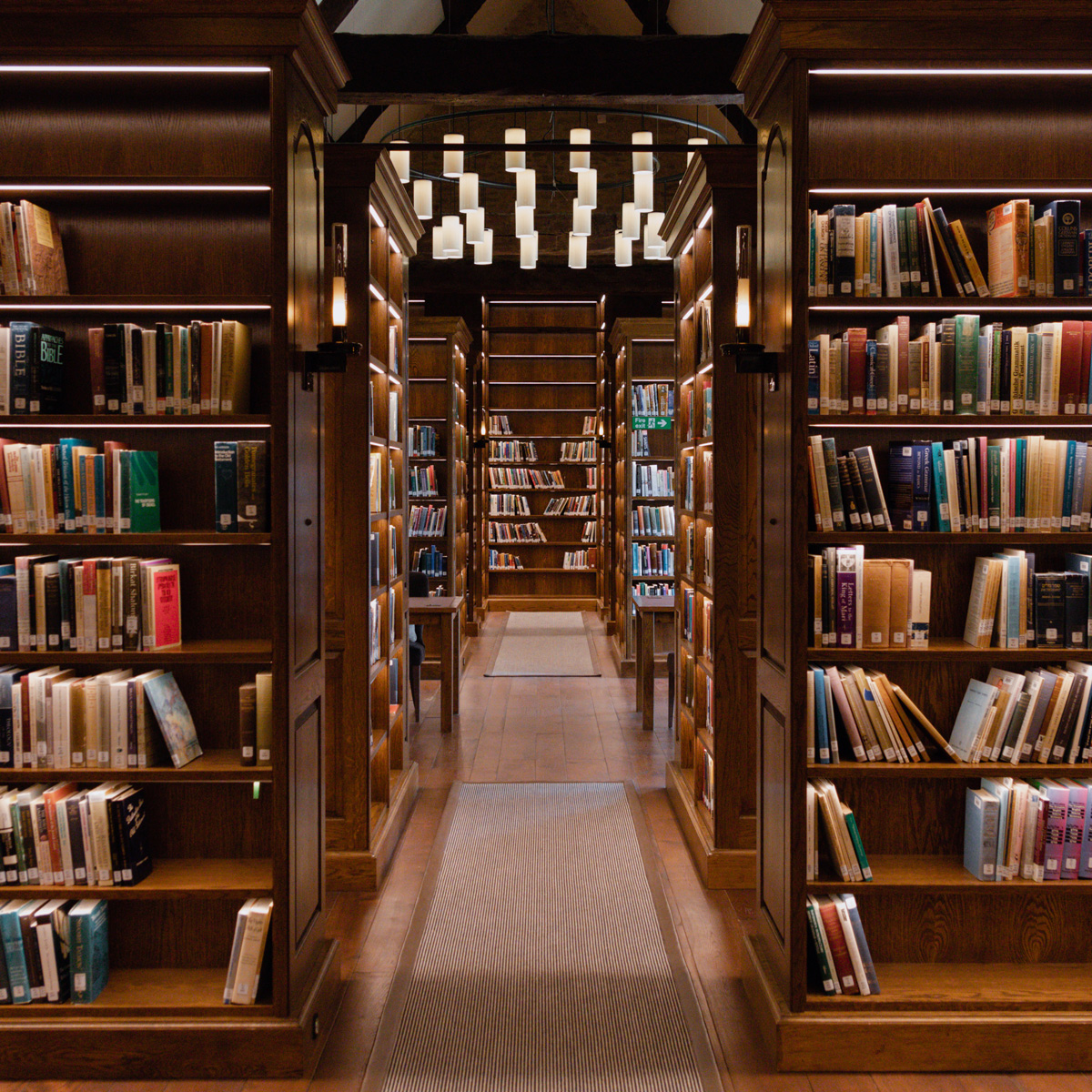 Biblioteka teologiczna Lanier z książkami po obu stronach i oświetleniem