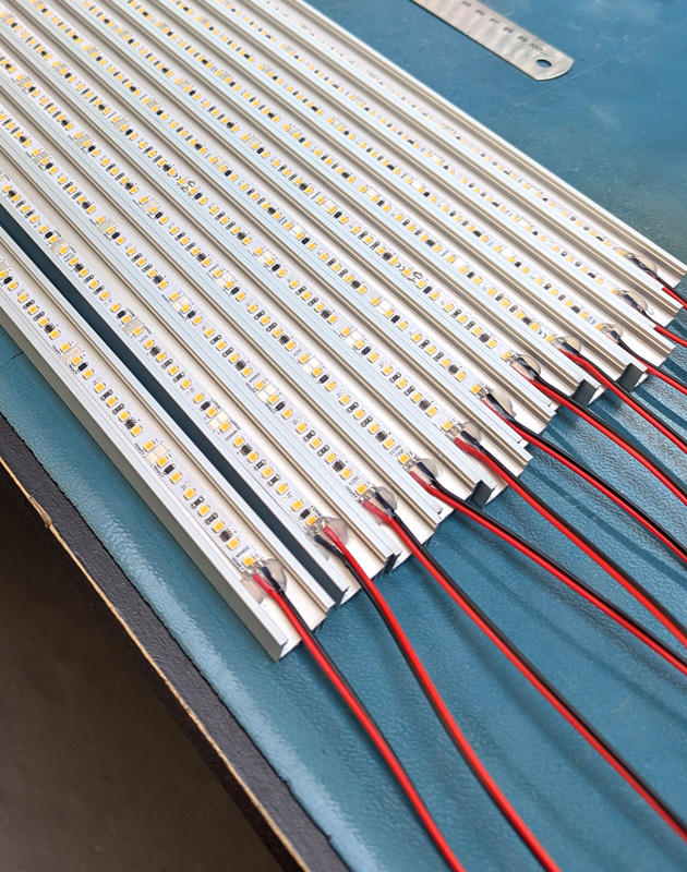 LED tape installed into profile with cabling for project on blue table